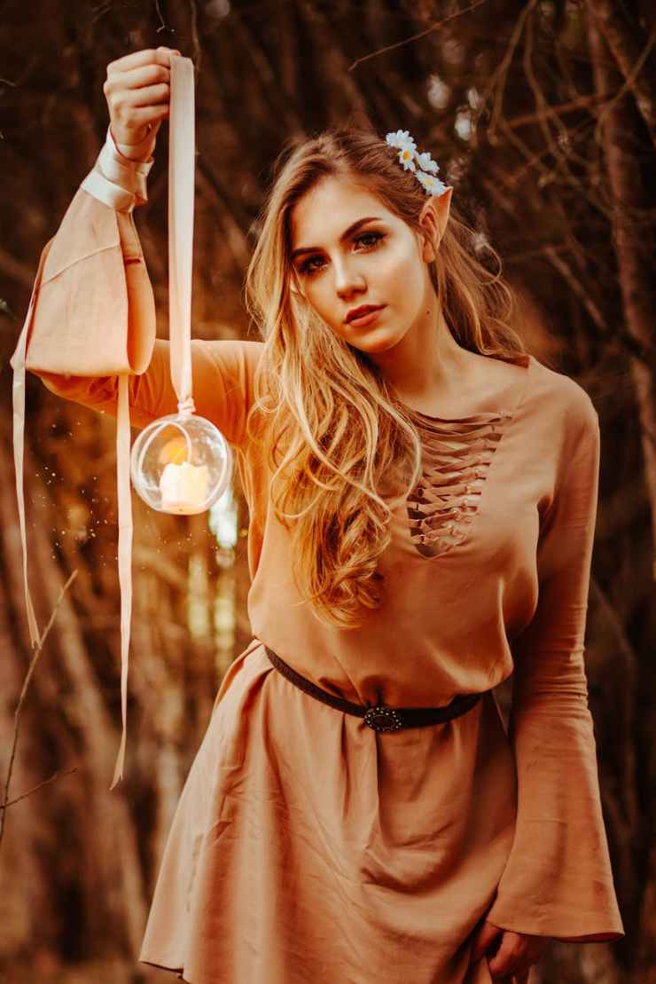woman wearing brown long sleeved shirt holding round glass terrarium